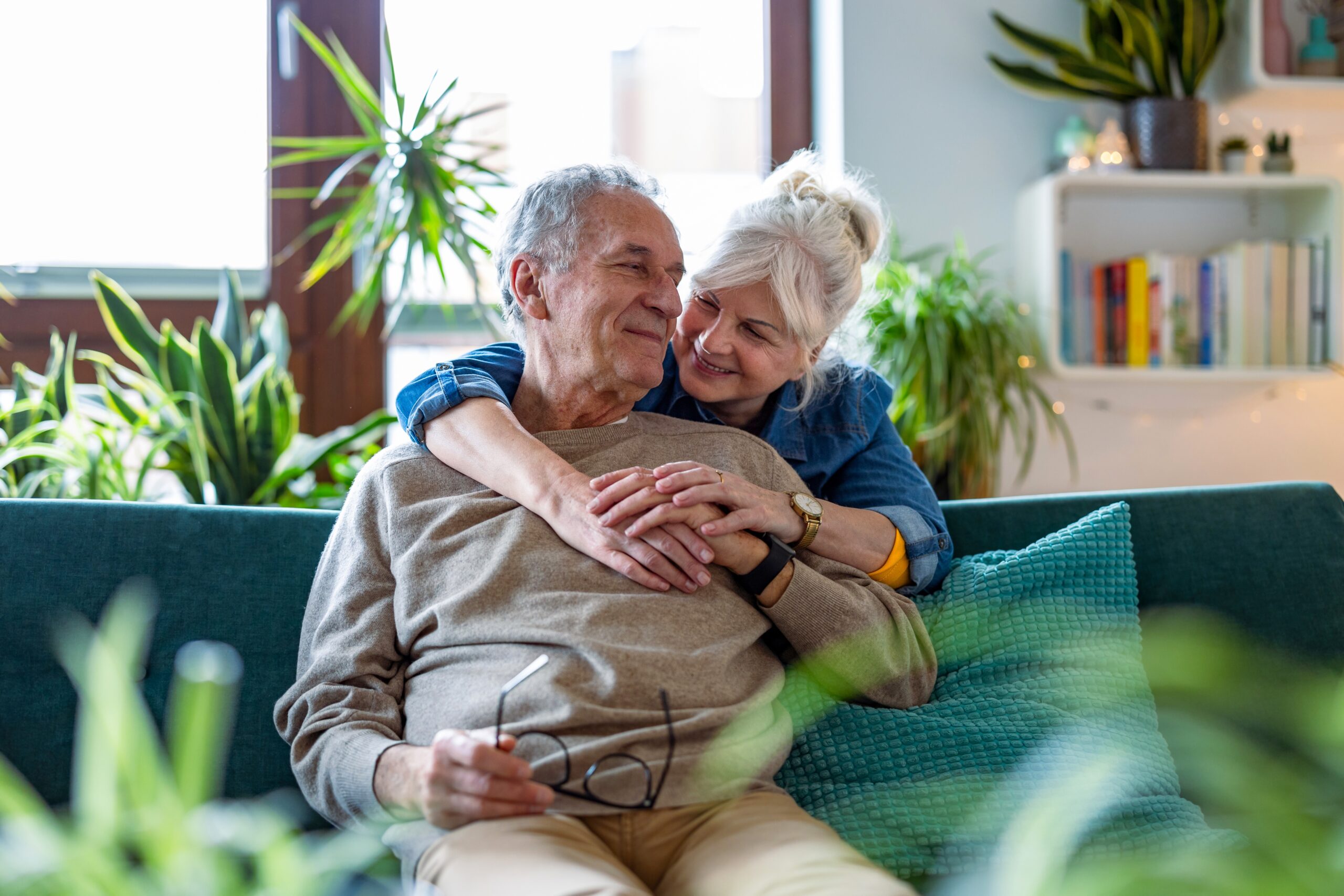 Retired couple hugging on sofa